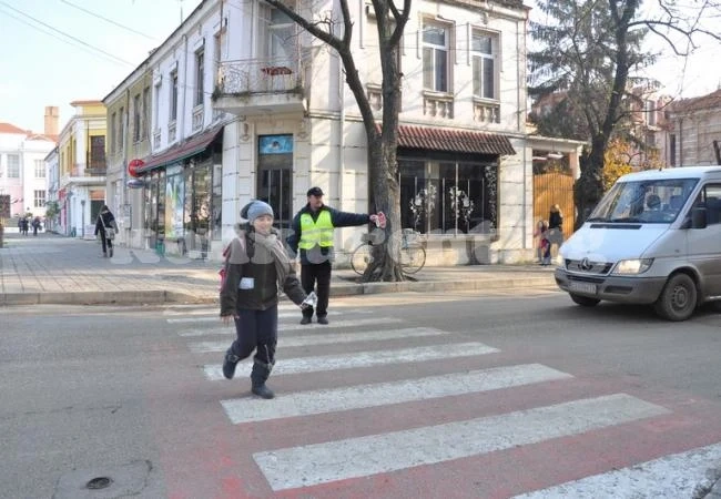 Работници помагат на малчугани за пресичането